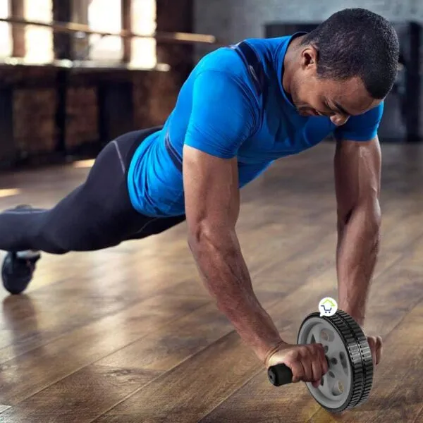 Hombre con rueda abdominal ejercitando brazos y abdomen en el gimnasio.