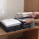Set x10 organizadores de ropa: camisas y pantalones apilados en un armario con separadores.