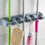 Organizador de pared para escobas y traperas, sostiene un cepillo y un paraguas.