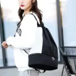 Bolso deportivo con cordón impermeable negro y blanco, con compartimento inferior con cremallera.