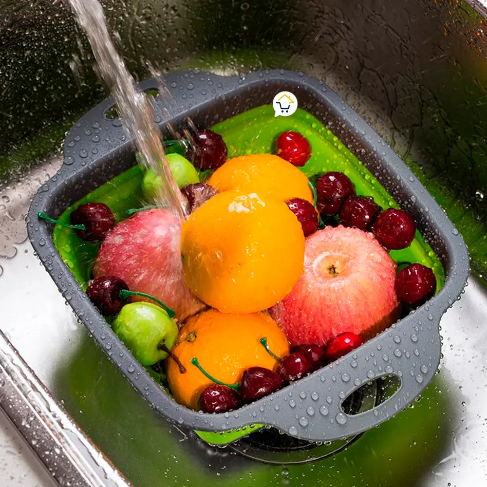Colador plegable de silicona lavando frutas y verduras en la cocina.