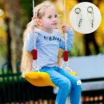 Niña sonriente en columpio amarillo de exterior, ideal para juego y diversión.