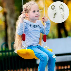 Niña sonriente en columpio amarillo de exterior, ideal para juego y diversión.