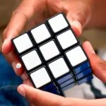 Set x2 Cubo Rubik 3x3 manos resolviendo rompecabezas mágico con caras blancas y azules.