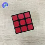 Cubo Rubik 3x3 rojo y negro en mesa de madera con logo " Real".