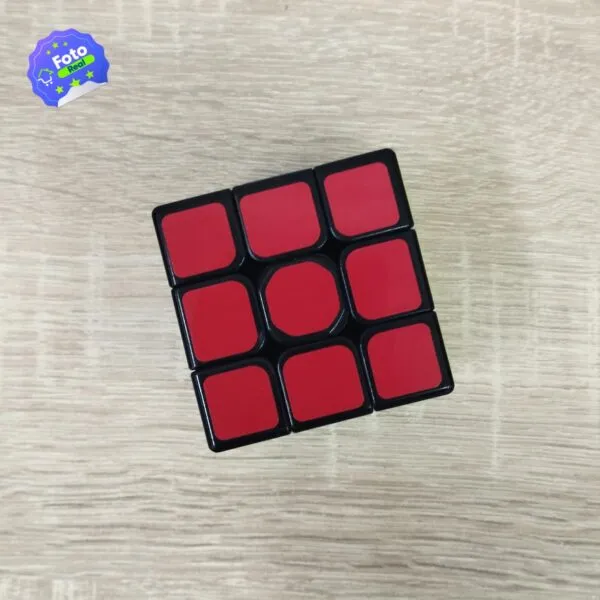 Cubo Rubik 3x3 rojo y negro en mesa de madera con logo " Real".