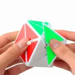 Cubo Rubik Rompecabezas mágico de 5.5cm con caras rojas y verdes sostenido en manos.