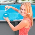 Set x2 dispensador de cloro flotante para piscina con mujer sonriente al lado.