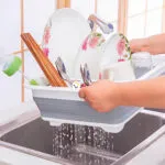 Escurridor plegable de platos Locero con cubiertos, vasos y rodillos para secar.