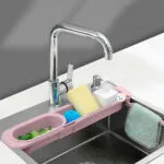 Escurridor plegable telescópico de cocina con esponja, jabón y toalla sobre el lavaplatos.