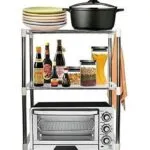 Estante organizador de cocina con horno eléctrico, ollas, botellas y despensa.