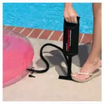 Inflador manual Intex Doble Quick II con flotador rosa, listo para usar junto a la piscina.