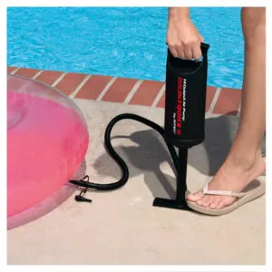 Inflador manual Intex Doble Quick II con flotador rosa, listo para usar junto a la piscina.