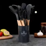 Juego de 12 utensilios de cocina de silicona resistentes al calor con soporte, color negro y madera.