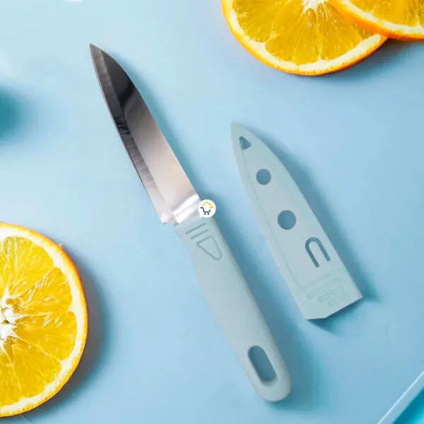 Cuchillo de cocina con mango gris y funda protectora junto a rodajas de naranja.