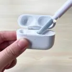 Kit de limpieza 5 en 1 para audífonos y teclados, limpiando un estuche blanco.