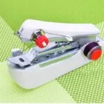 Mini máquina de coser de mano portátil blanca con hilo morado, ideal para reparaciones rápidas.