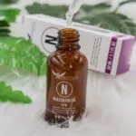 Sérum Afrodita Niacinamida 10% con Zinc, gota de pipeta y botella de vidrio ámbar.