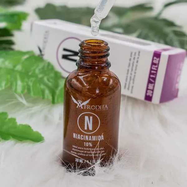 Sérum Afrodita Niacinamida 10% con Zinc, gota de pipeta y botella de vidrio ámbar.