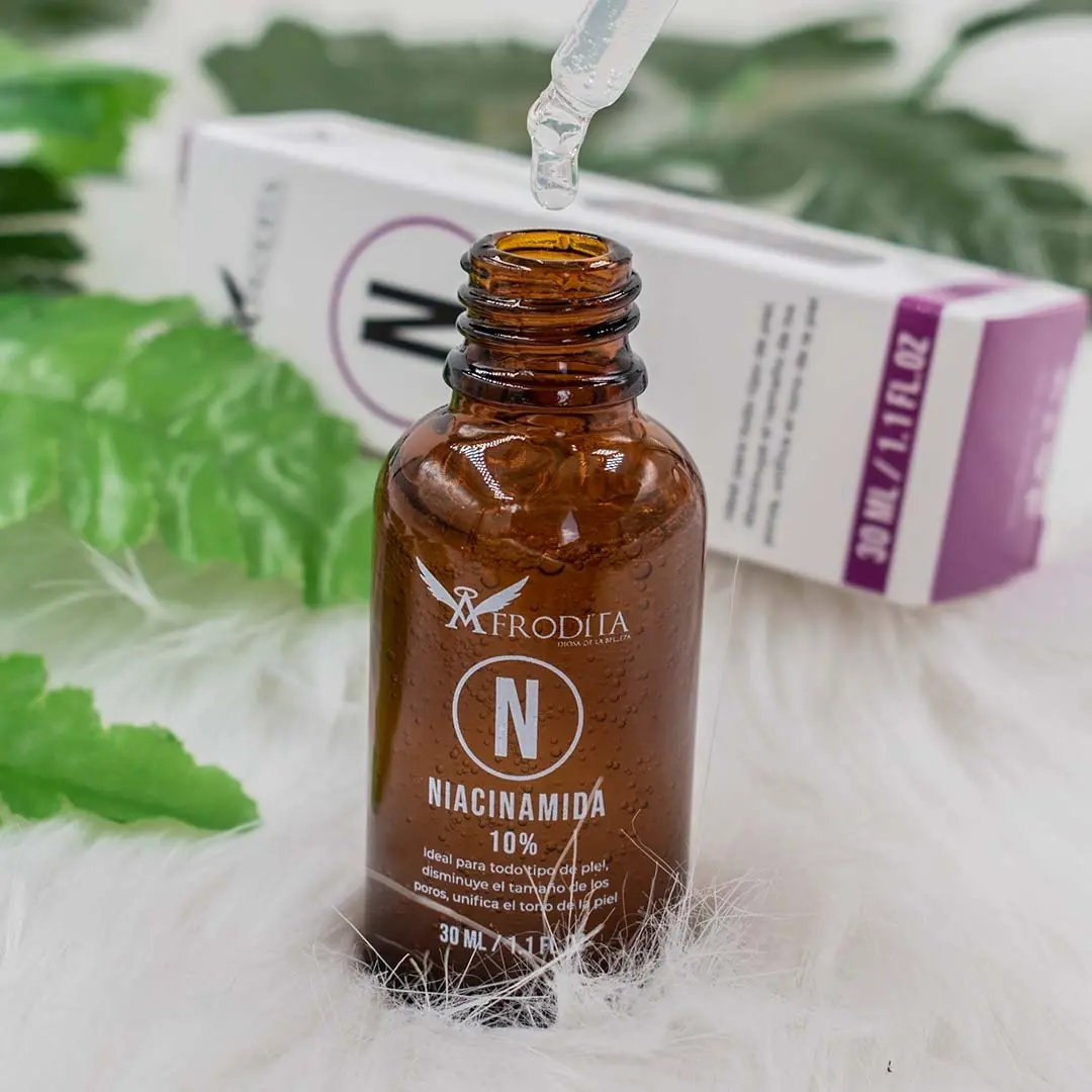 Sérum Afrodita Niacinamida 10% con Zinc, gota de pipeta y botella de vidrio ámbar.