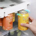 Dispensador de bebidas en lata para nevera, mano sacando una lata de bubbly de durazno.