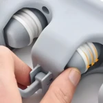 Detalle de organizador de escobas y traperas, mano manipulando para ajustar.