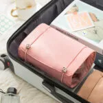 Organizador viajero rosa con 4 cartucheras plegables, ideal para cosméticos y accesorios en tu maleta.