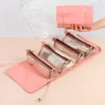 Organizador viajero plegable con 4 cartucheras transparentes para cosméticos y brochas.