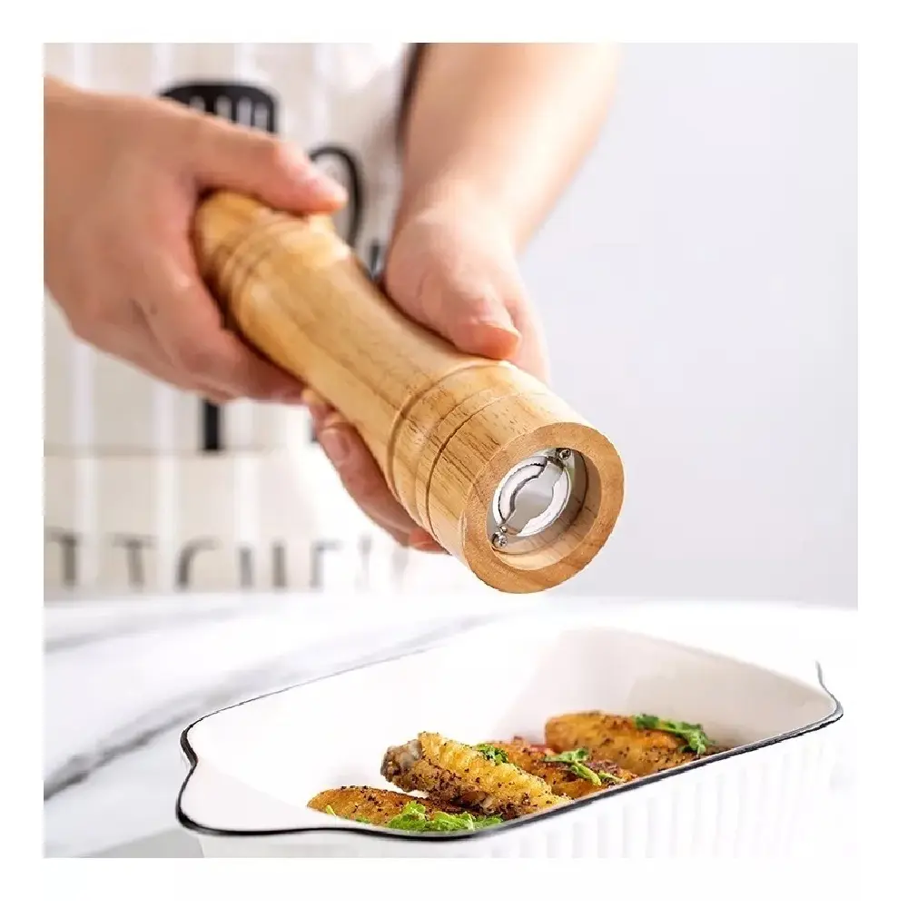 Pimentero de madera con muela molinillo, ideal para condimentar alitas de pollo recién horneadas.