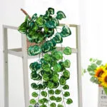 Planta artificial colgante de hojas en forma de corazón en maceta de mimbre.
