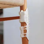 Rascador para gatos con púas flexibles que se adhiere a patas de muebles para auto-rascado y masaje.