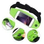Riñonera deportiva verde con celular, billetera y audífonos, ideal para correr.