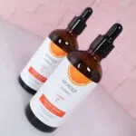 Set x2 Serum Vitamina C Bioaqua 100ml, botellas ámbar con aplicador cuentagotas sobre fondo rosa.