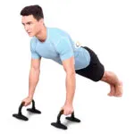 Hombre en posición de plancha con soportes para flexiones de pecho negros y naranjas, entrenamiento fitness.