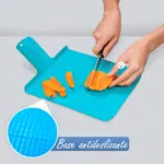 Tabla de cortar plegable azul con base antideslizante, picando zanahoria.