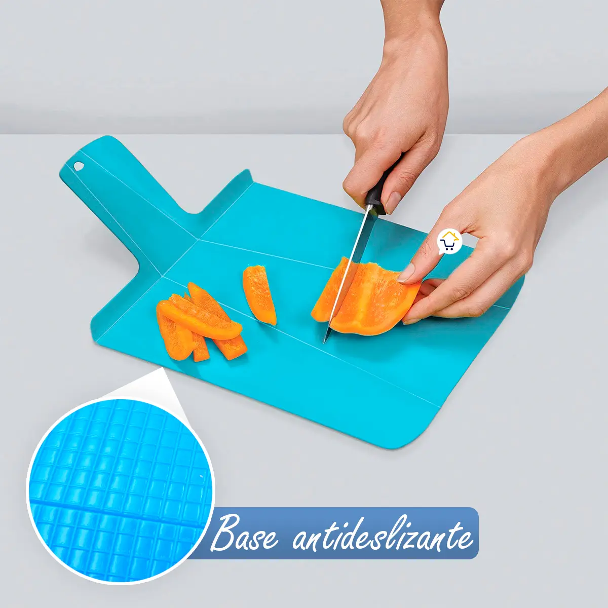 Tabla de cortar plegable azul con base antideslizante, picando zanahoria.
