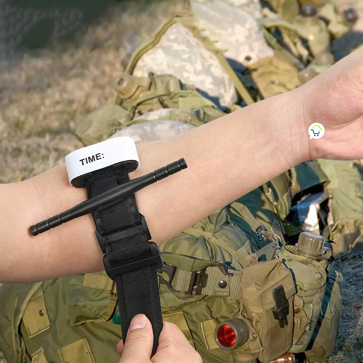 Torniquete médico de emergencia de una mano aplicado a un brazo, equipo táctico militar.