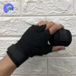 Mano con vendas de boxeo negras para entrenamiento de deportes de contacto, asegurando muñeca y puño.