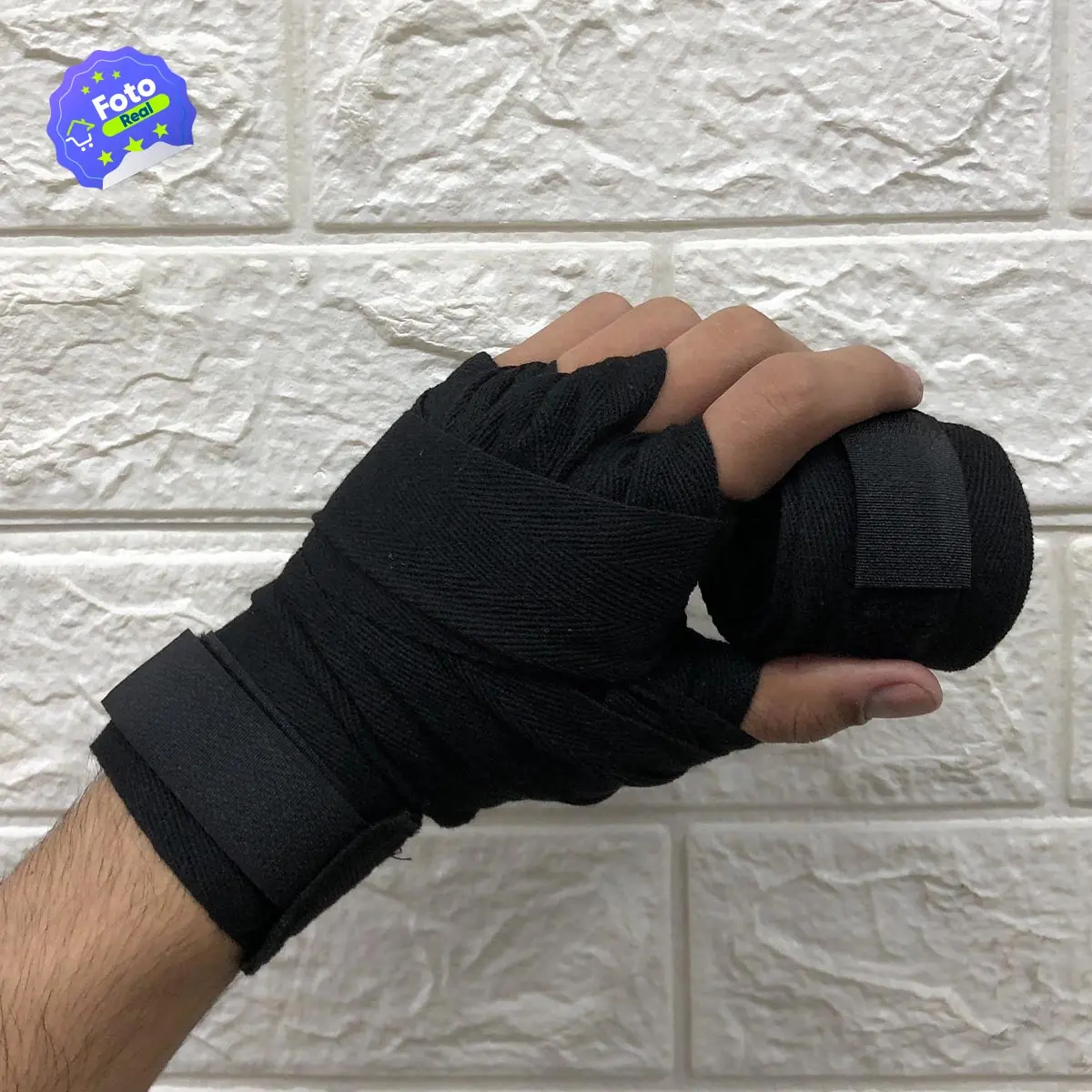 Mano con vendas de boxeo negras para entrenamiento de deportes de contacto, asegurando muñeca y puño.