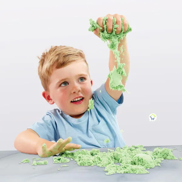 Niño jugando con arena cinética verde para moldear, relajante y kinética.