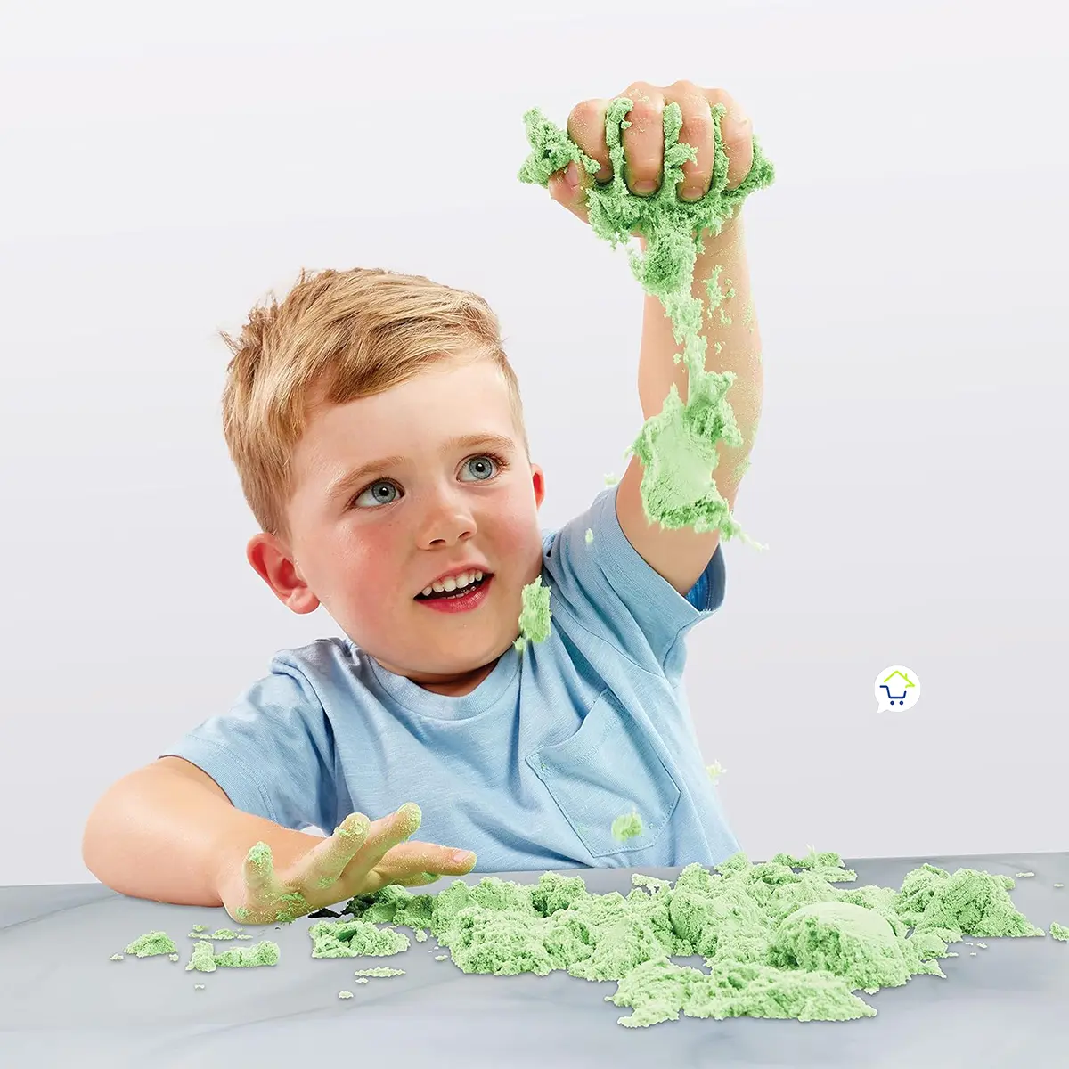 Niño jugando con arena cinética verde para moldear, relajante y kinética.