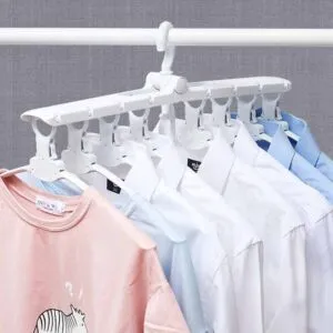 Colgador mágico 8 en 1 para organizar camisas, camisetas y ropa en un tendedero blanco.