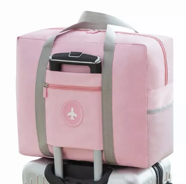 Maleta plegable rosa con compartimento para equipaje de mano, ideal para viajes.