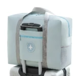 Maleta plegable de viaje impermeable, bolso compacto y ligero azul celeste con asa de carrito.
