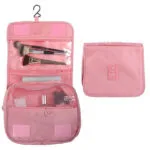 Cosmetiquera organizadora de viaje colgante rosada con compartimentos transparentes y cierre.