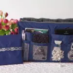 Organizador expandible azul para bolsos y maletas de dama, con accesorios y flores.