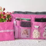 Organizador expandible rosa para bolsos, maletas y damas de viaje, con compartimentos y accesorios.