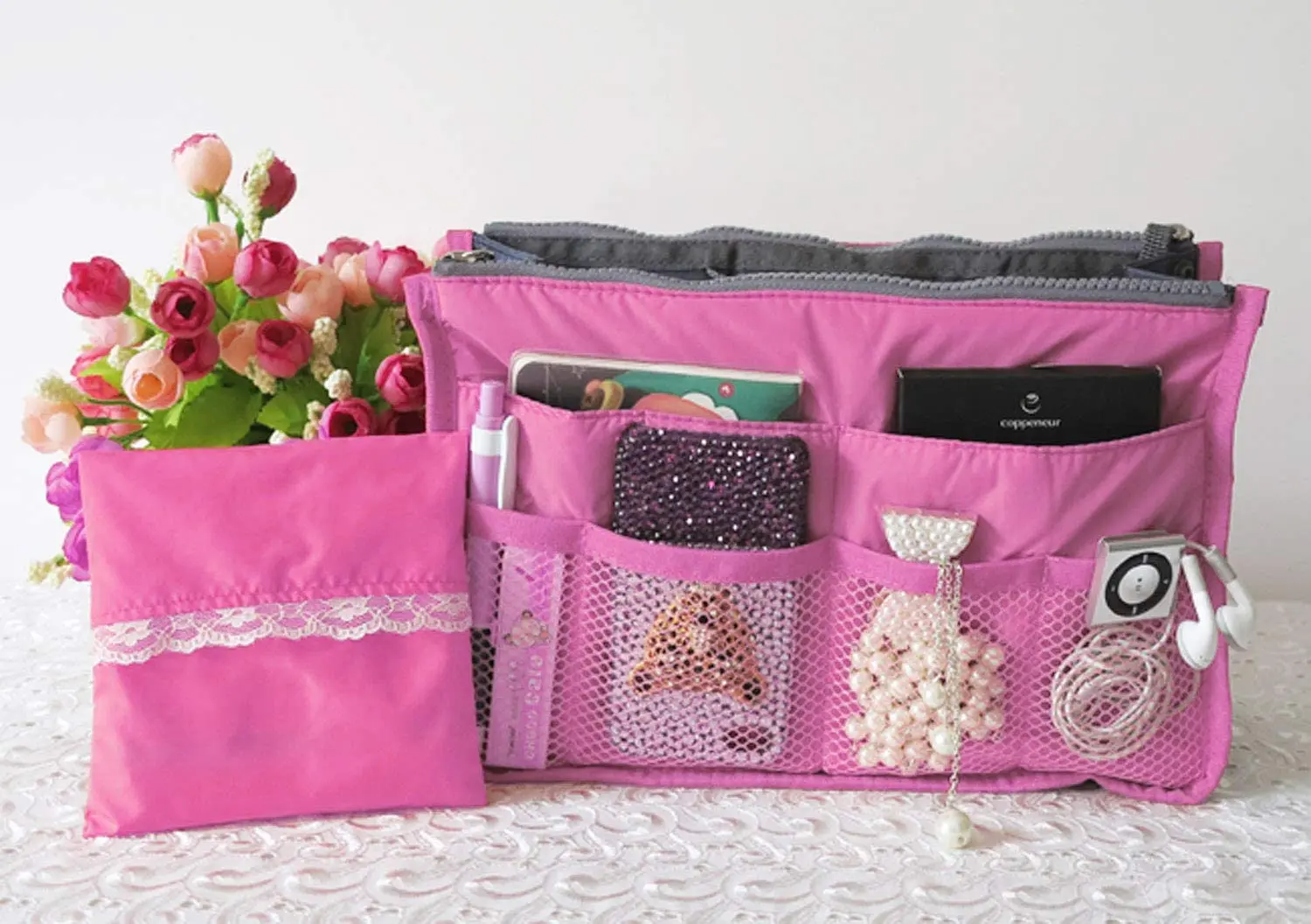 Organizador expandible rosa para bolsos, maletas y damas de viaje, con compartimentos y accesorios.