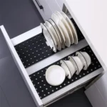 Bandeja organizadora retráctil para escurrir platos y cuencos blancos en un cajón de cocina moderno.