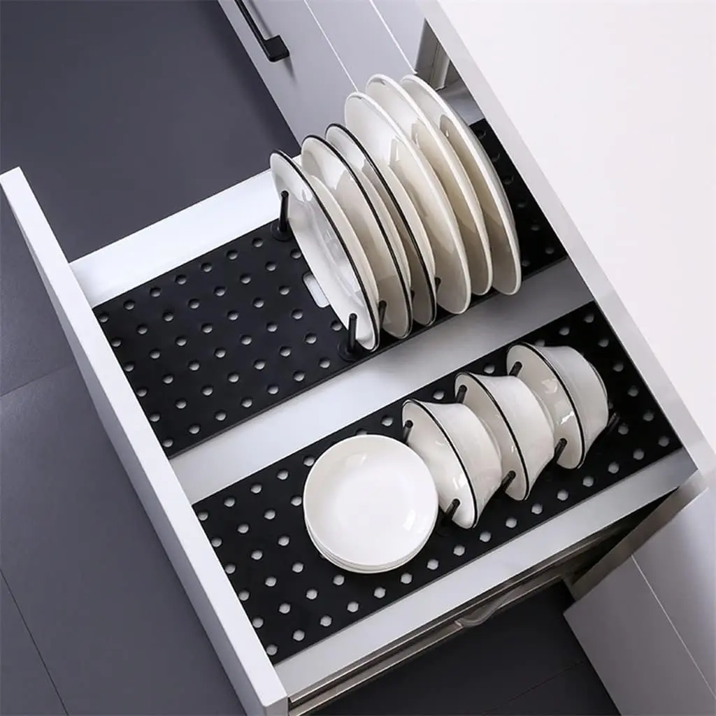 Bandeja organizadora retráctil para escurrir platos y cuencos blancos en un cajón de cocina moderno.